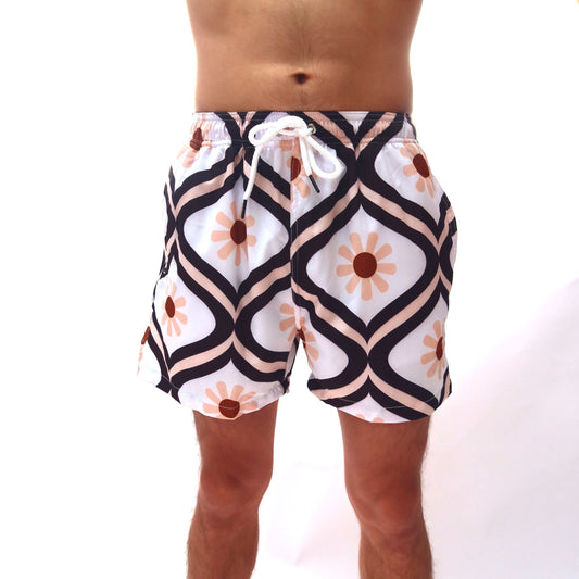 Person wearing patterned swim shorts on a white background