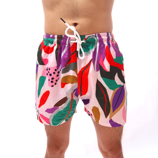 Colorful abstract-patterned swim shorts worn by a person on a white background