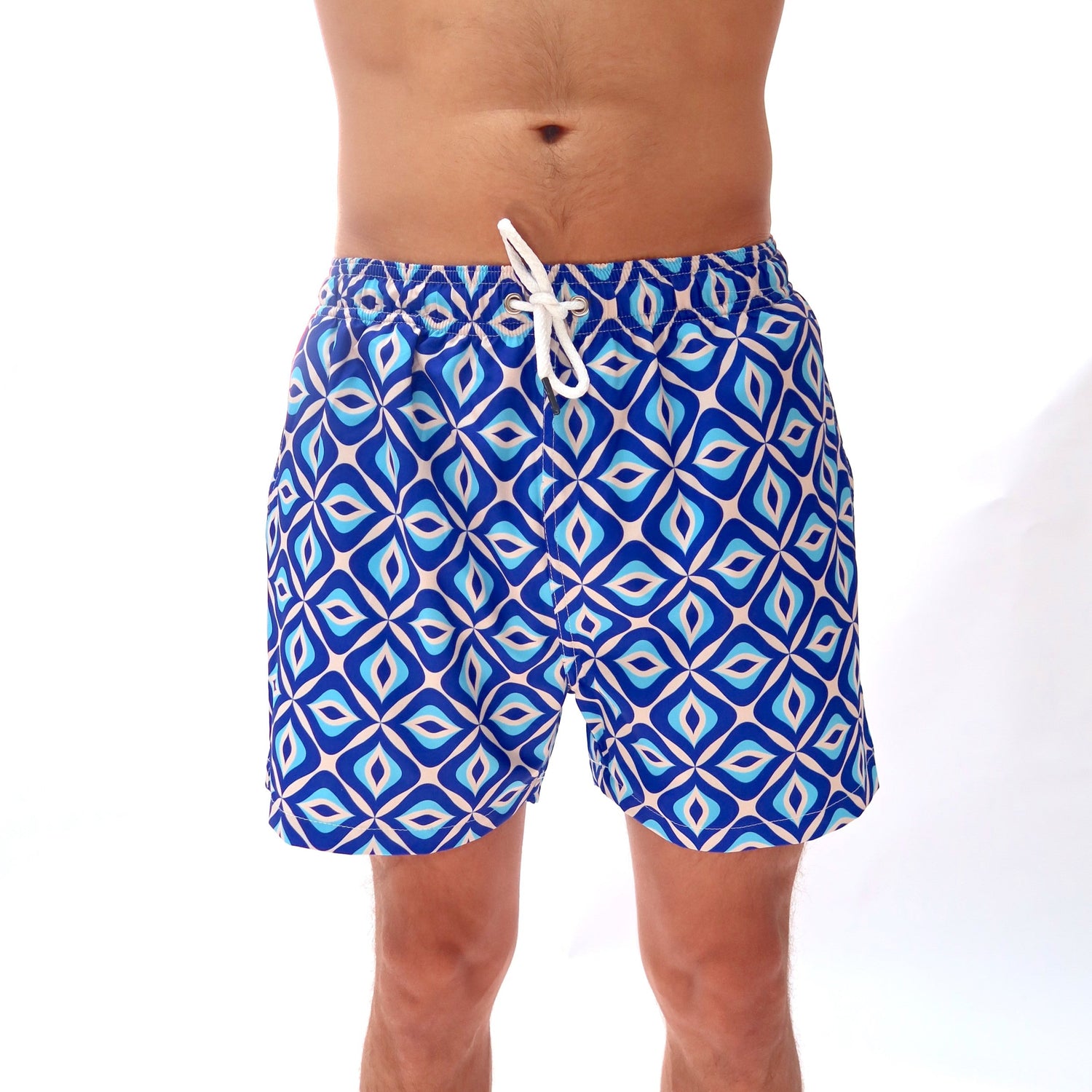 Blue patterned swim shorts worn by a person on a white background
