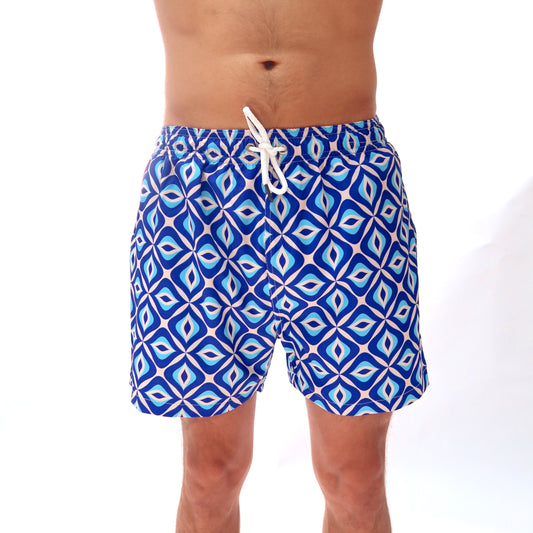 Blue patterned swim shorts worn by a person on a white background